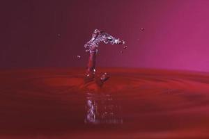 splash resulting from the impact of a drop with a container full of water photo