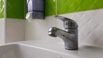 Old aluminum sink mixer. Water tap in the toilet for clean hands. photo