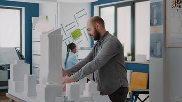 Man architect analyzing building model and maquette to design urban property video