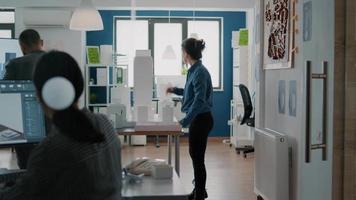 Woman engineer looking at building model to design construction layout on blueprints plan video