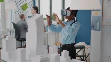 Architektin, die eine VR-Brille trägt, um das Baulayout und das Gebäudemodell zu entwerfen