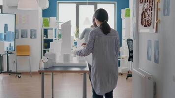 equipe de diversos arquitetos trabalhando juntos no projeto do modelo de construção com plantas video