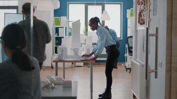 mujer ingeniera que trabaja con una computadora portátil y un modelo de construcción para diseñar planos en papel video