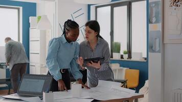 team di architetti che lavorano con tablet per analizzare il piano dei progetti sul tavolo video