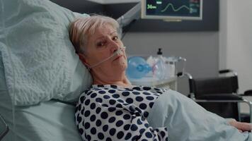 Portrait of old patient laying in bed with nasal oxygen tube video