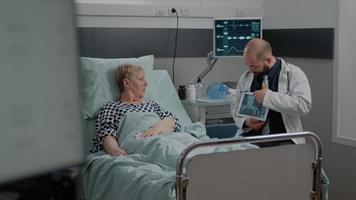 medico che indica il display del tablet con radiografia per donna malata video