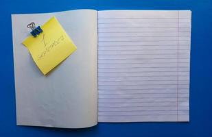 Open notebook on a white lining on a blue wooden tabletop photo