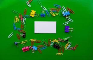 pile of paper clips isolated on green background, documents, office supplies concept, dirty office desk. Empty place for writing and text. Top view, layout. flat lay photo