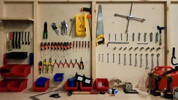 Ukraine, Kiev - May 09, 2020. Work tools on the board and in the workshop. Workshop scene. A lot of old tools on a dirty desktop. The concept of carpentry and painting. photo