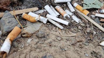 A lot of cigarette butts. The cause of lung cancer. Many used cigarette butts as trash photo