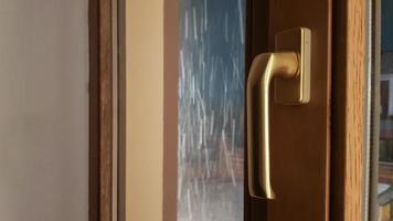 Closed brown plastic window in the house. Close-up on a pen. Lamination of window glass film, a package of wood light brown photo