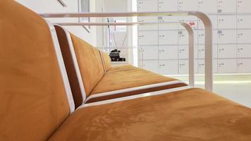 close-ups of benches upholstered in brown suede or leather with white metal railing in a cinema waiting room in a shopping center photo