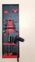 Work tools in a modern wall-mounted plastic small organizer. Vertical photo