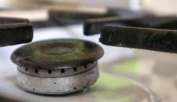 Dirty gas stove in the kitchen for cooking with vegetable oil stains and burnt food debris on the surface, close-up. Selective focus. Grease-covered gas hob in the kitchen. photo