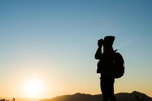 silueta de mujer turista de pie en la montaña foto