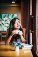Portrait asian woman smiling relax in coffee shop cafe photo