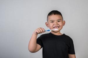 Niño cepillándose los dientes en la foto de estudio