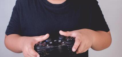 Happy boy play game computer with a controller in studio photo