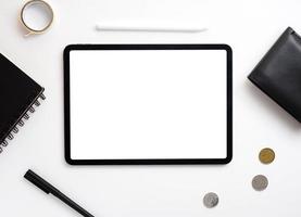 flat lay photography of the tablets and stationary on the white desk. an object photographed with a white black screen for copy space. a background for message and information content. photo