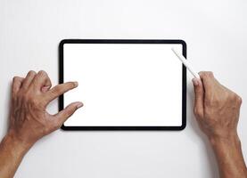 Men use digital tablets on desks with blank screens for mock up. A flat lay image of a man holding a stylus pen with a blank copy space screen for your text message or information content. photo