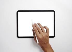 los hombres usan tabletas digitales en escritorios con pantallas en blanco para simulacros. una imagen plana de un hombre sosteniendo un lápiz óptico con una pantalla de espacio de copia en blanco para su mensaje de texto o contenido de información. foto