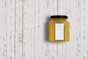 Top up up view orange jam jar isolated on white wooden background. suitable for your design project. photo