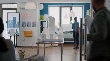 Man architect placing blueprints plan on table to design building model and layout video