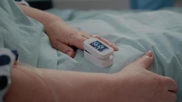 Close up of oximeter on finger showing low oxygen saturation video