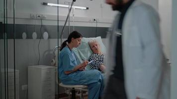Enfermera haciendo consulta con la mujer enferma para el cuidado de la salud. video