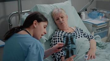 Medical assistant pointing at radiography for consultation video