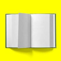 Back to school concept , hard cover dark green book middle turning isolated on yellow. photo