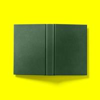 Back to school concept , hard cover dark green book open upside down isolated on yellow. photo