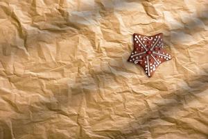 Close up of Christmas gingerbread cookie on brown paper background. photo