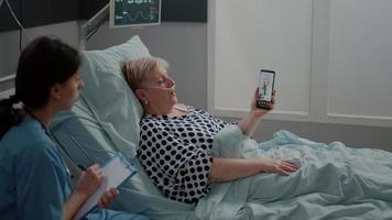 Sick woman using video call on smartphone for appointment