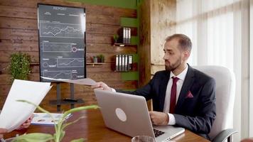 Businessman in suit giving his colleague finacial charts video