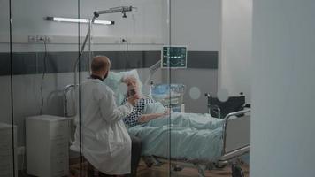 medico che dà una bottiglia di pillole per un paziente anziano con malattia video