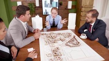 Arquitecta explicando su proyecto inmobiliario a jóvenes inversores. video