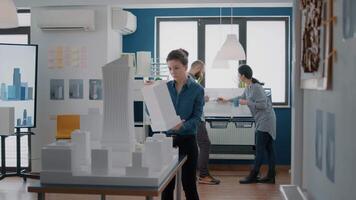 Portrait of employee working with building model and maquette to design blueprint plan video