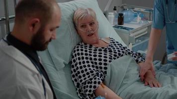 close-up van oudere patiënt die in bed ligt en praat met medic video