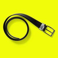 Top up up view black leather belt isolated on yellow background. suitable for your design project. photo