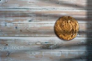 peanut butter on a plate with salted peanuts. paleo diet and keto diet food on wooden table. photo