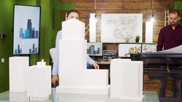 Young female architect taking photos of building models video