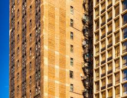 Block of flats in Chicago, apartment building in downtown against the blue sky, house made of brown bricks photo