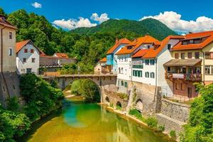 paisaje urbano de skofja loka, eslovenia. Vista del puente de los capuchinos sobre el río selska sora en el centro de la ciudad vieja foto