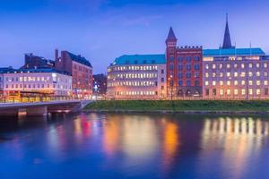 View of the night city reflected in water. Malmo cityscape, Scania, Sweden photo