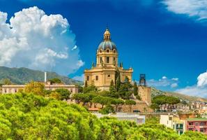 Cityscape of Messina on sunny summer day with beautiful cumulus clouds. View of a yellow Church in Baroque architectural style. Sicily, Italy photo