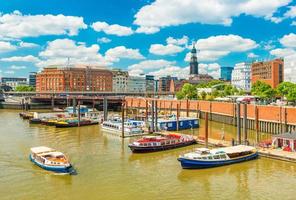 Hamburg cityscape at sunny summer day. View of the harbor with touristic boats. Popular travel destination in the northern Europe