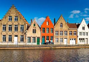 Brugge, Bruges, Belgium. Colored houses in the traditional architecture style and canal with water.