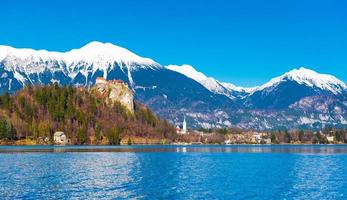 lago sangrado en eslovenia. montañas nevadas con cielo azul claro en el fondo foto
