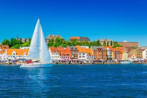 Beautiful panorama of a European port city. A yacht is sailing against the skyline of the city of Flensburg, Germany photo